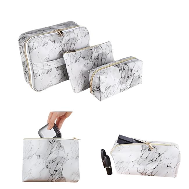 Set di tre beauty case in marmo bianco e nero, con cerniera dorata, ideale per trucco e cosmetici. Design elegante e pratico per viaggi.