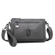 Borsa a tracolla in pelle grigia con tasca frontale, chiusura a zip e dettagli metallici. Elegante e pratica per uso quotidiano.