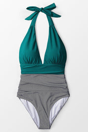 Costume intero donna verde con scollo a V e righe bianche e nere, design elegante, perfetto per la spiaggia o la piscina.
