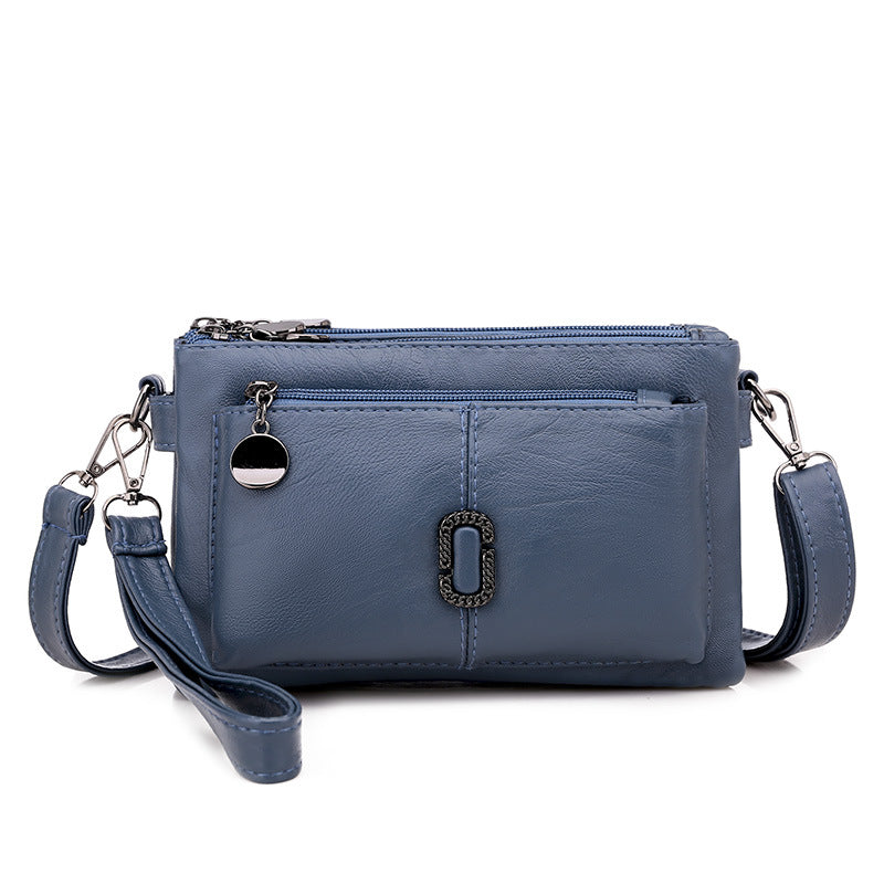 Borsa a tracolla in pelle blu con cerniera, tasca frontale e dettagli metallici. Elegante e pratica per uso quotidiano. Accessorio moda donna.