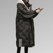 Cappotto lungo nero imbottito da donna con cappuccio, dettagli a righe bianche, ideale per l'inverno. Stile casual e moderno.