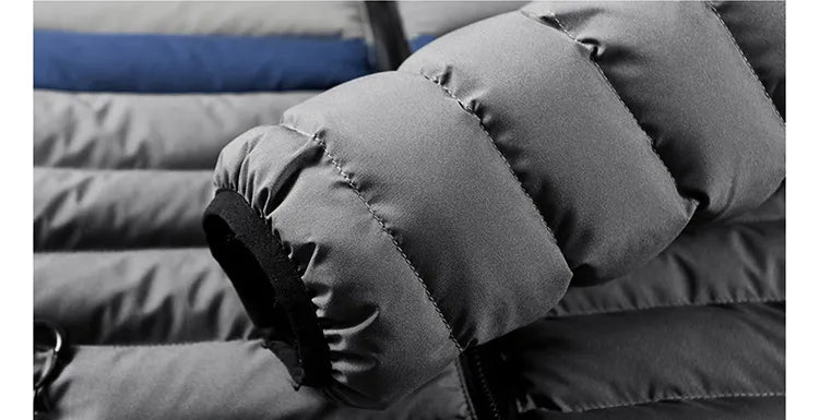Giacca invernale imbottita grigia, dettaglio manica, tessuto impermeabile, design trapuntato, moda uomo, abbigliamento caldo e resistente.