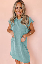 Abito estivo donna verde menta, maniche a volant, tessuto leggero, perfetto per look casual. Modello sorridente su sfondo rosa.