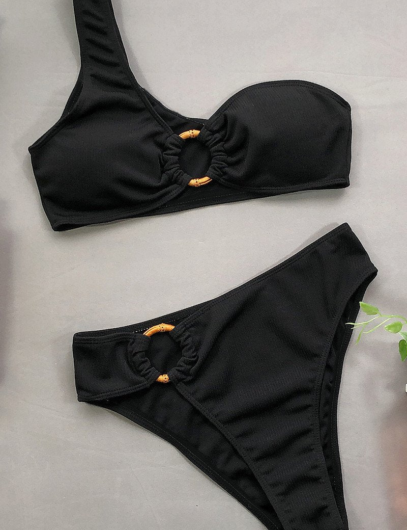 Costume da bagno bikini nero a un solo spallino con dettagli ad anello. Design elegante e moderno, perfetto per la moda mare estiva.