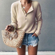 Donna con maglione beige e shorts di jeans, borsa di paglia intrecciata. Moda casual estiva, abbigliamento femminile trendy.