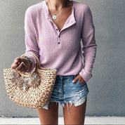 Donna con maglione rosa a coste, shorts di jeans strappati e borsa di paglia intrecciata. Look estivo casual, moda femminile trendy.