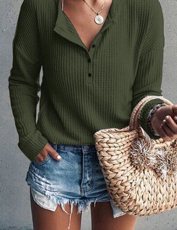 Donna con maglione verde a coste, jeans corti e borsa di paglia intrecciata. Moda casual estiva, abbigliamento femminile trendy.