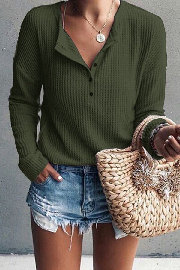 Donna con maglione verde a coste, jeans corti e borsa di paglia intrecciata. Moda casual estiva, abbigliamento femminile trendy.