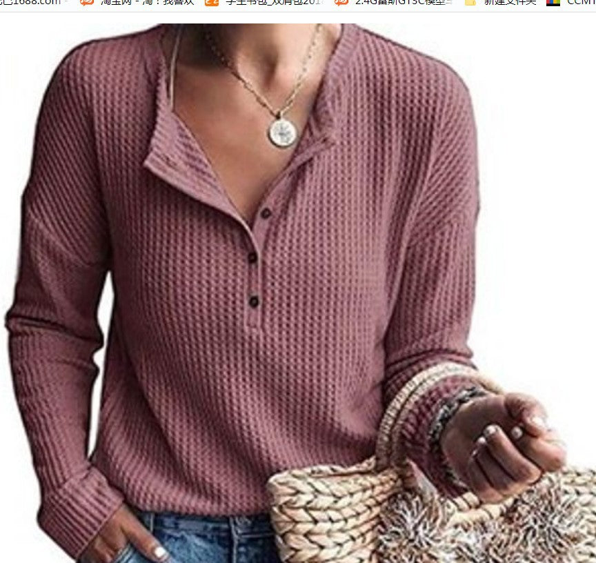 Maglia donna rosa a maniche lunghe con bottoni, tessuto a trama waffle, abbinata a jeans blu e borsa in paglia. Moda casual autunnale.