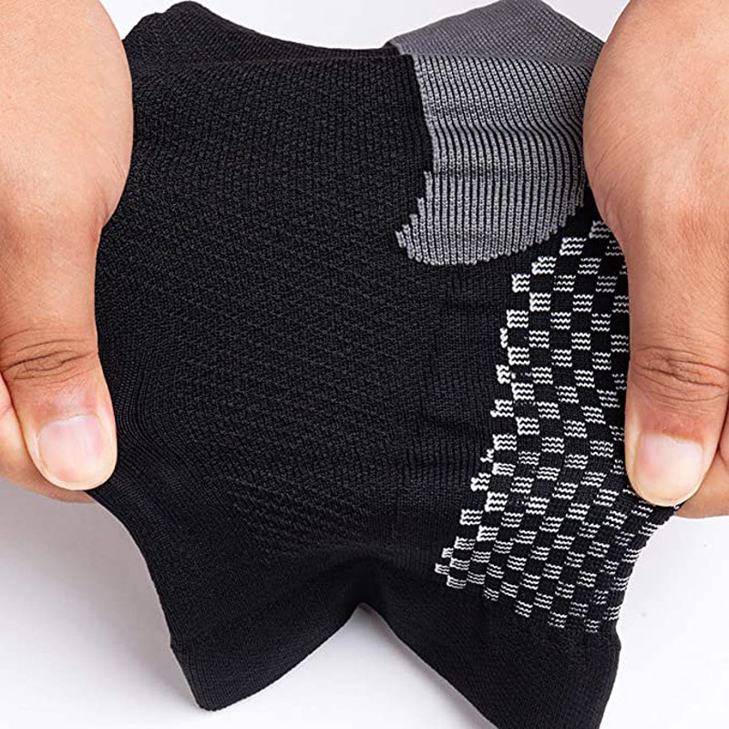 Mani che tengono calzini sportivi neri e grigi, tessuto traspirante e antiscivolo, ideale per attività fisica, comfort e prestazioni ottimali.