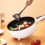 Padella elettrica bianca con manico in legno, cottura di verdure fresche. Utensile da cucina moderno, ideale per cucinare in modo rapido ed efficiente.