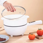Pentola bianca con coperchio in vetro, manico ergonomico, su tavolo di legno con pomodori freschi. Ideale per cucina moderna e cottura versatile.