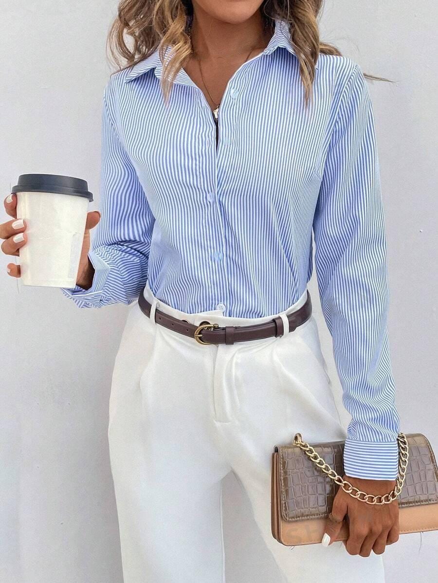Donna con camicia a righe blu e bianche, pantaloni bianchi eleganti, cintura marrone, borsa a tracolla beige e caffè da asporto. Moda casual chic.