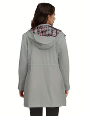Giacca impermeabile donna grigia con cappuccio, fodera a quadri, vista posteriore. Elegante e funzionale per pioggia. Moda autunnale.