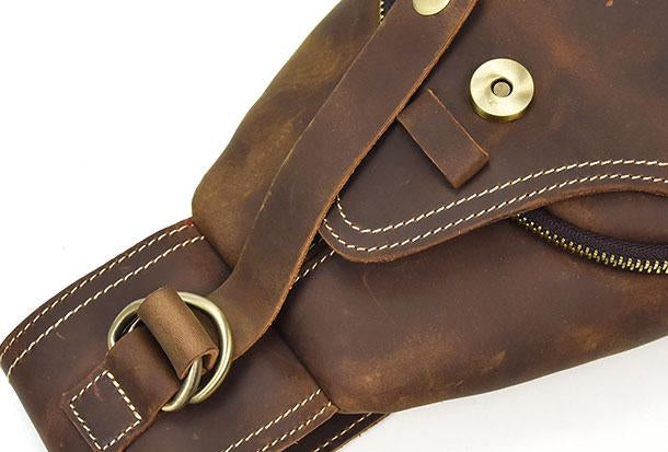 Borsa a tracolla in pelle marrone con cuciture bianche, chiusura a zip e fibbia in metallo. Accessorio moda uomo/donna elegante e resistente.