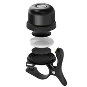 Campanello bici nero esploso, design compatto, componenti interni visibili, montaggio manubrio, accessorio ciclismo essenziale, alta qualità.
