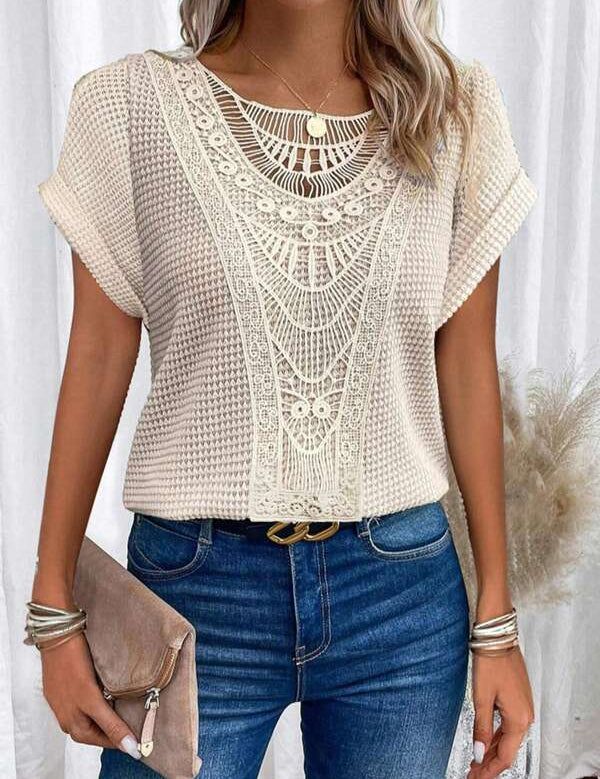 Blusa beige in pizzo crochet, maniche corte, abbinata a jeans blu. Accessori: bracciali argento, borsa a mano marrone. Moda casual elegante donna.