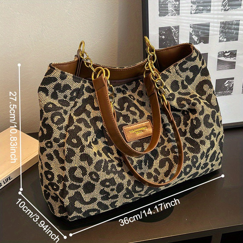 Borsa a tracolla leopardata in tessuto, dimensioni 36x27,5x10 cm, con manici in pelle marrone e catene dorate, su sfondo moderno.