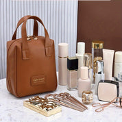 Borsa da viaggio marrone in pelle sintetica con zip, circondata da cosmetici e accessori su tavolo di marmo. Elegante e pratica per organizzare il trucco.