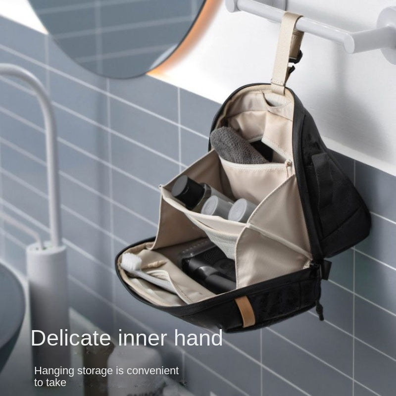 Borsa da toilette sospesa nera in bagno moderno, con scomparti aperti e prodotti da viaggio. Organizzatore da viaggio pratico e compatto.