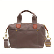 Borsa a tracolla in nylon marrone con manici in pelle, dettagli dorati e tracolla regolabile. Design elegante e funzionale per uso quotidiano.
