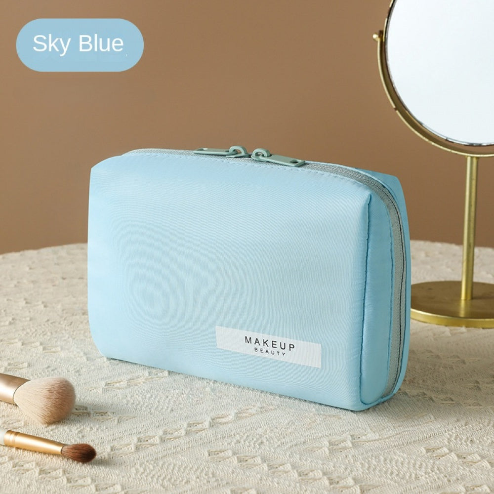 Astuccio trucco azzurro su tavolo con specchio e pennelli, ideale per cosmetici. Design elegante, perfetto per organizzare il make-up quotidiano.