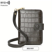 Portafoglio in pelle marrone con texture coccodrillo, cinturino da polso e protezione RFID. Design elegante e funzionale per sicurezza e stile.