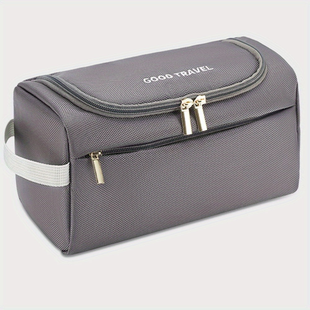 Borsa da viaggio grigia con cerniera, manico laterale e tasca frontale, ideale per organizzare accessori da viaggio. Design compatto e resistente.