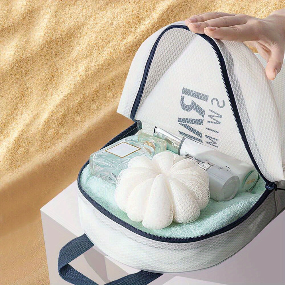 Borsa da viaggio trasparente con cerniera, contenente profumo, lozione e spugna da bagno, su sfondo sabbioso. Accessori da bagno essenziali.