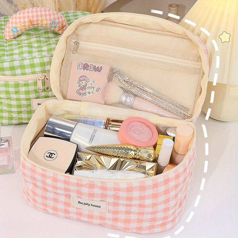 Astuccio da trucco a quadretti rosa con cosmetici vari, tra cui rossetti, cipria e profumo. Design elegante, ideale per organizzare il make-up.