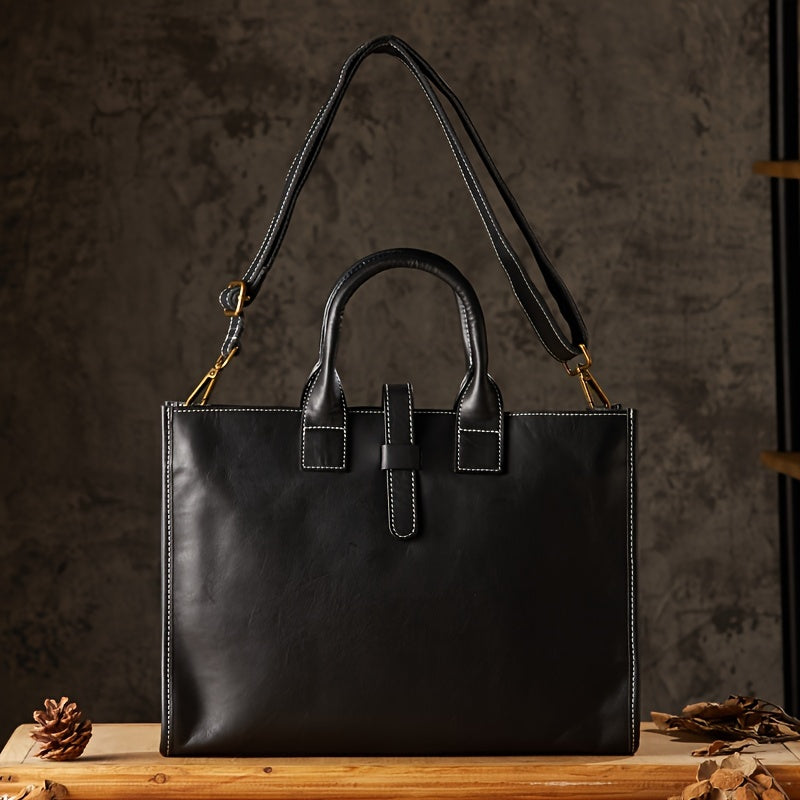 Borsa a mano in pelle nera con tracolla regolabile, cuciture bianche a contrasto, su sfondo rustico. Elegante accessorio moda donna.