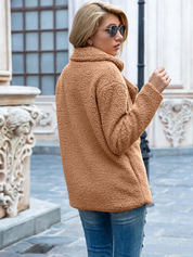 Donna con giacca in pelliccia sintetica marrone, jeans, occhiali da sole, in strada urbana. Moda autunnale, abbigliamento casual elegante.