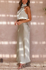 Abito lungo elegante in raso color crema, senza maniche, con scollo drappeggiato. Perfetto per cerimonie e serate speciali.
