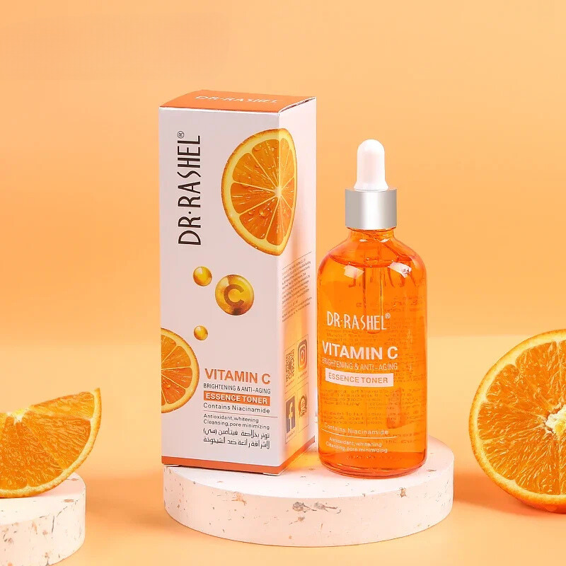 Bottiglia di tonico alla vitamina C Dr. Rashel con scatola, arance fresche sullo sfondo. Tonico illuminante e anti-età per la cura della pelle.