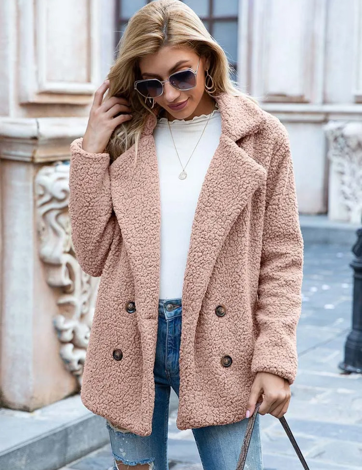 Donna con cappotto teddy beige, occhiali da sole, jeans strappati e maglia bianca. Moda autunnale, abbigliamento casual elegante.