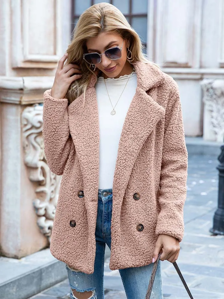 Donna con cappotto teddy beige, occhiali da sole, jeans strappati e maglia bianca. Moda autunnale, abbigliamento casual elegante.