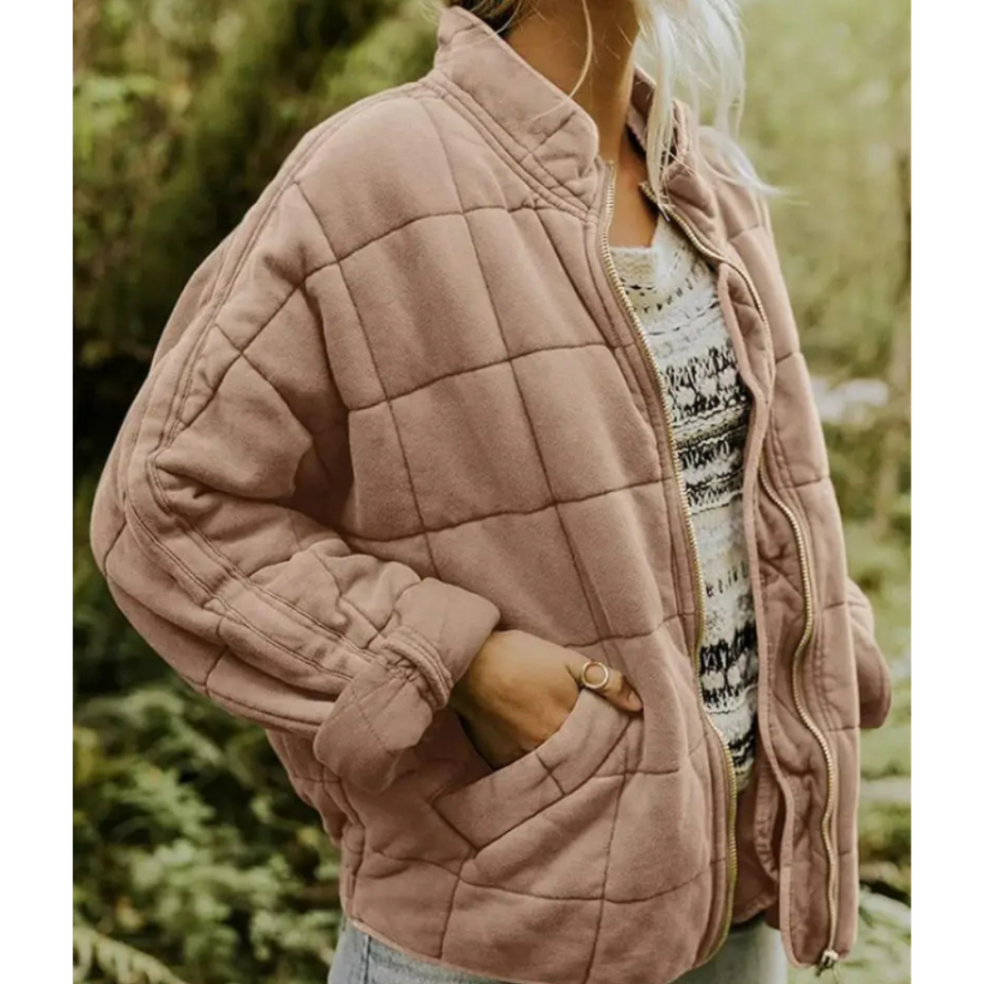 Giacca trapuntata rosa donna, stile casual, con tasche laterali, indossata su maglia a fantasia. Moda autunnale, abbigliamento femminile trendy.
