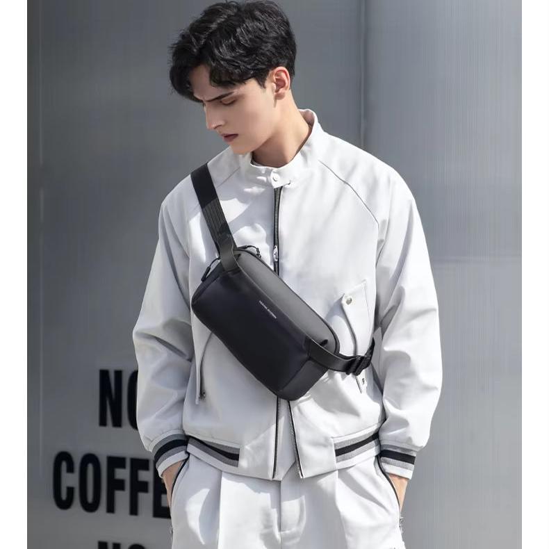 Giovane uomo con giacca bianca e marsupio nero a tracolla. Moda urbana, abbigliamento casual, accessori uomo, stile contemporaneo.