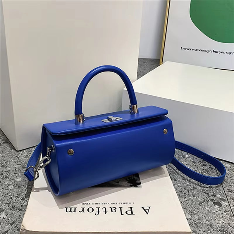 Borsa a mano blu elegante su sfondo neutro, design moderno con manico e tracolla, perfetta per moda donna e accessori di tendenza.