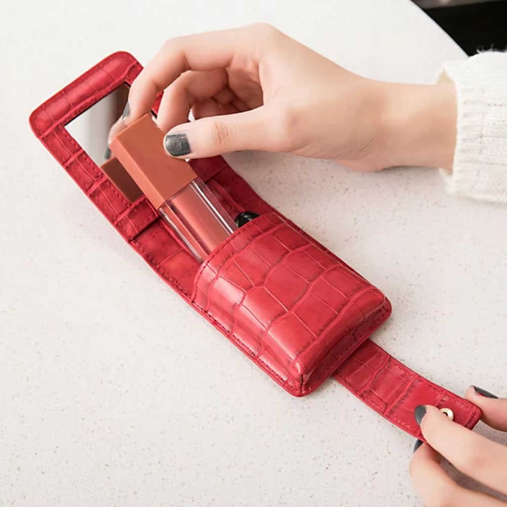 Custodia rossetto rossa in pelle con specchio, design elegante, mani femminili, accessorio trucco portatile, moda donna, organizzazione cosmetici.