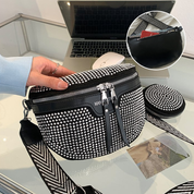 Borsa a tracolla nera con strass, cerniera doppia, cinturino regolabile, su tavolo con laptop. Elegante accessorio moda donna.