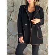 Cappotto nero donna elegante, doppio petto, dettagli marroni, moda autunno inverno, abbigliamento femminile, sfondo pietra naturale.
