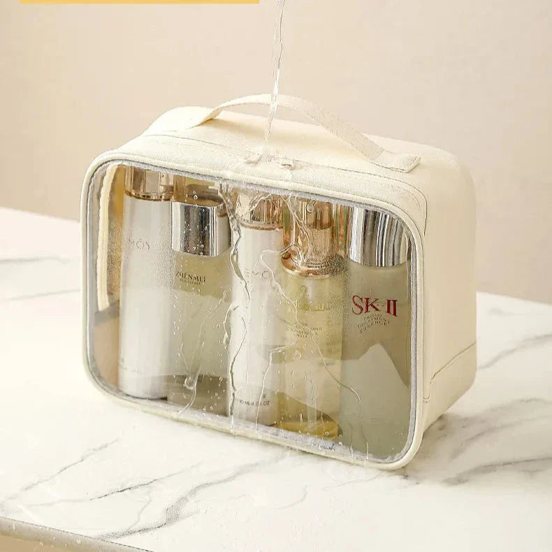 Borsa trasparente impermeabile con prodotti skincare, ideale per viaggi. Include flaconi di cosmetici di lusso, perfetta per organizzare articoli da toeletta.