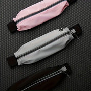 Tre marsupi sportivi impermeabili in rosa, grigio e nero su sfondo nero. Design moderno con cerniera, ideali per corsa e attività all'aperto.