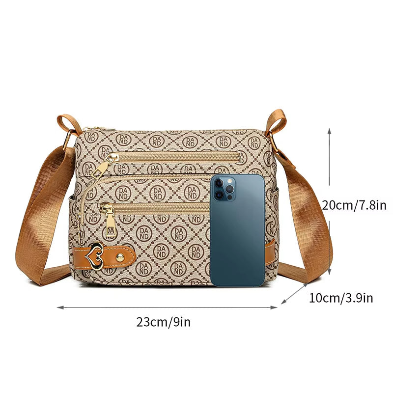Borsa a tracolla beige con motivo geometrico, tasche multiple, cerniere dorate, cinturino regolabile e smartphone blu per dimensioni.