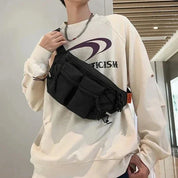 Uomo con felpa beige e marsupio nero a tracolla, design moderno, moda casual, accessorio pratico, stile urbano, corridoio interno.