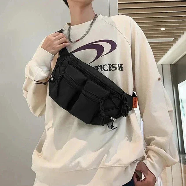 Uomo con felpa beige e marsupio nero a tracolla, design moderno, moda casual, accessorio pratico, stile urbano, corridoio interno.