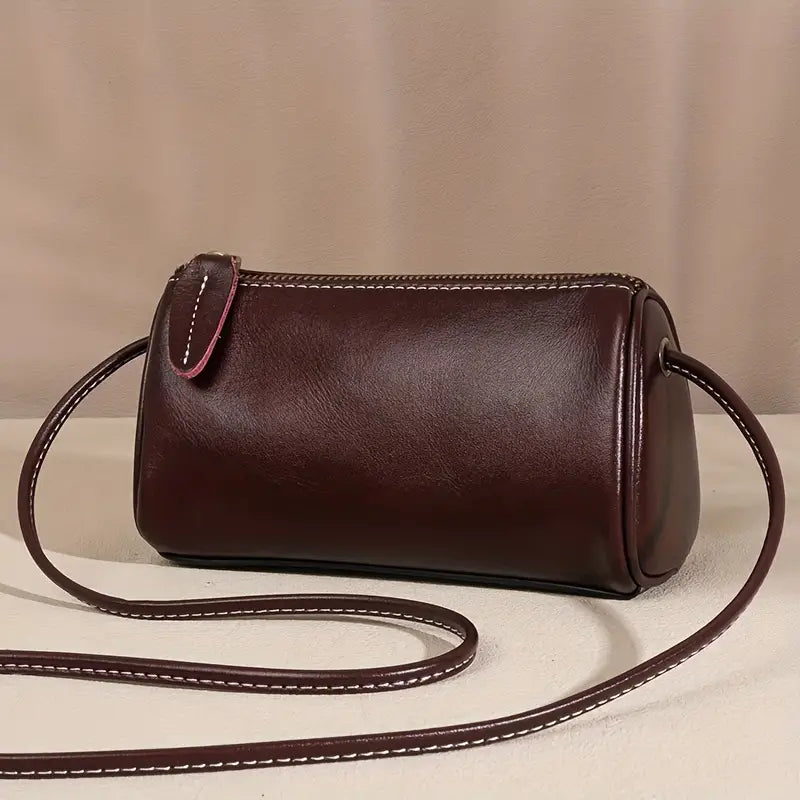 Borsa a tracolla cilindrica in pelle marrone scuro, design elegante e minimalista, perfetta per moda donna, accessori di lusso, stile casual chic.