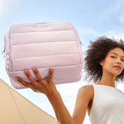 Donna con borsa a tracolla imbottita rosa, design moderno, ideale per viaggi e lavoro. Accessorio moda femminile, pratico e capiente.