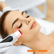Donna riceve trattamento viso con dispositivo ultrasuoni, estetista in guanti bianchi. Cura della pelle, bellezza, ringiovanimento viso.